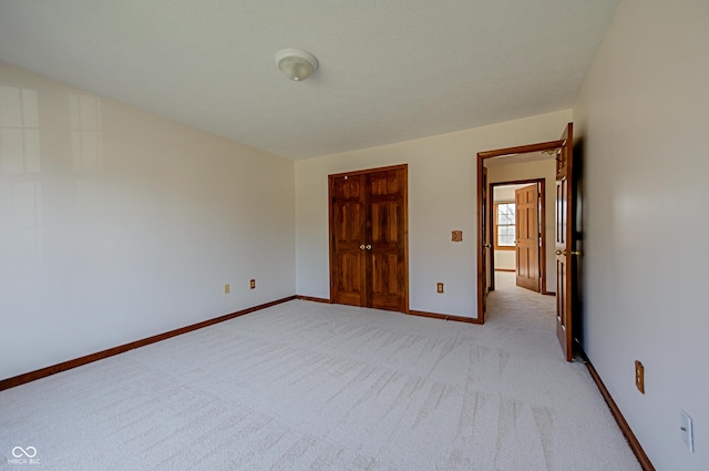 unfurnished bedroom featuring light carpet and a closet