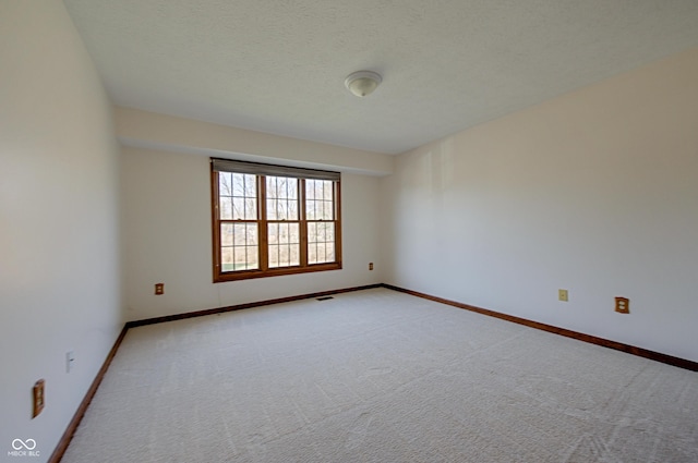 unfurnished room featuring light carpet and a textured ceiling