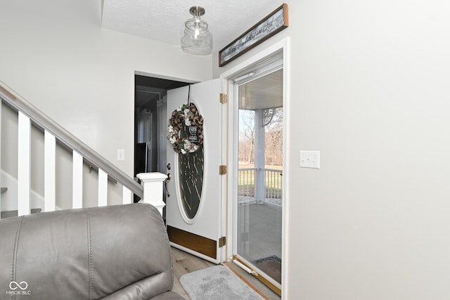 foyer featuring a textured ceiling and light wood-type flooring