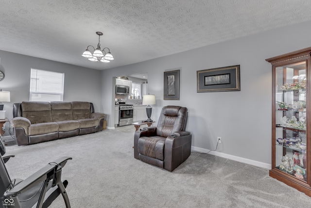 carpeted living room with a notable chandelier, a textured ceiling, and a wealth of natural light