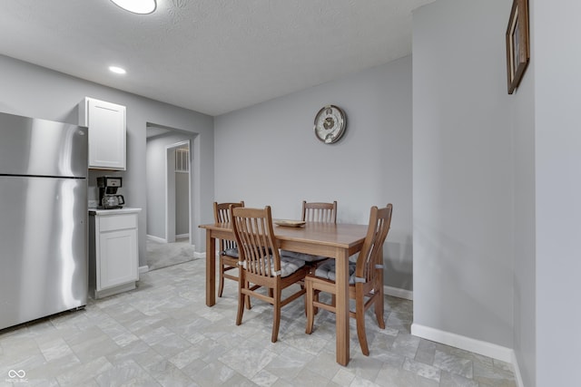 dining area featuring a textured ceiling