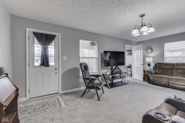 carpeted living room with a textured ceiling and a chandelier