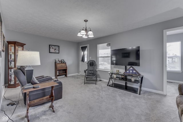 living room featuring light carpet, a wealth of natural light, a textured ceiling, and a chandelier