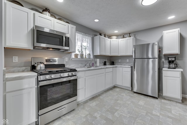 kitchen with white cabinetry, sink, a textured ceiling, and appliances with stainless steel finishes