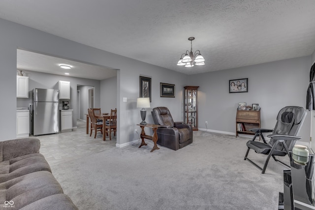 carpeted living room with a chandelier and a textured ceiling