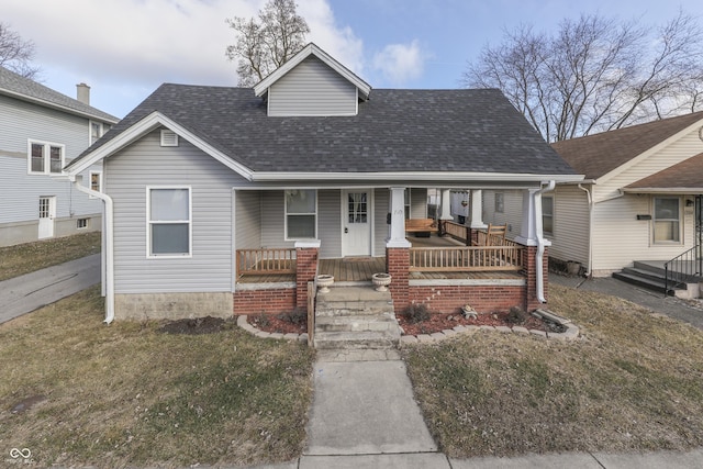 bungalow-style home with covered porch and a front yard