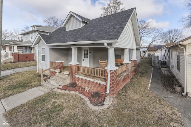 bungalow with a porch and a front lawn