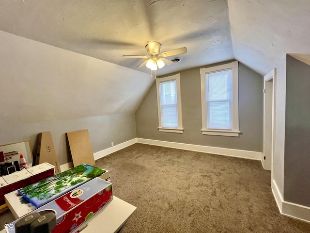 bonus room featuring dark colored carpet, lofted ceiling, and ceiling fan