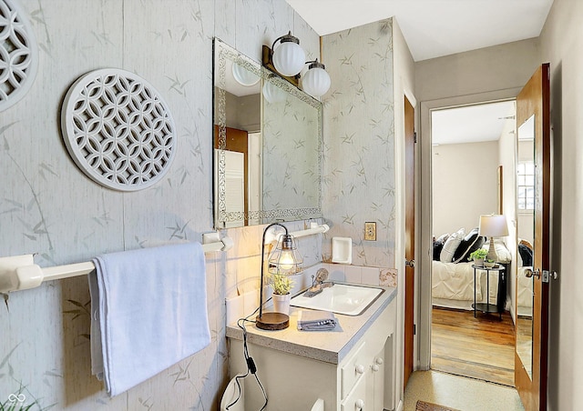 bathroom with vanity, ensuite bathroom, and wallpapered walls