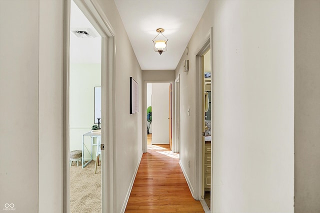 hall with light wood finished floors and baseboards