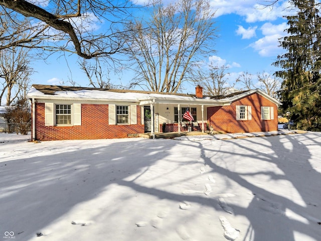 ranch-style home with a chimney and brick siding