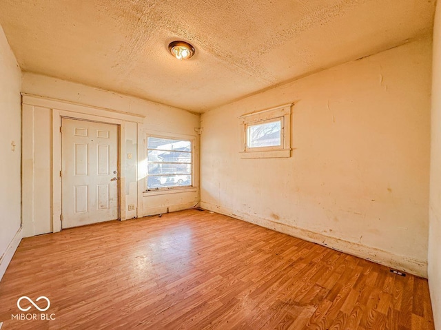 empty room with hardwood / wood-style flooring and a textured ceiling