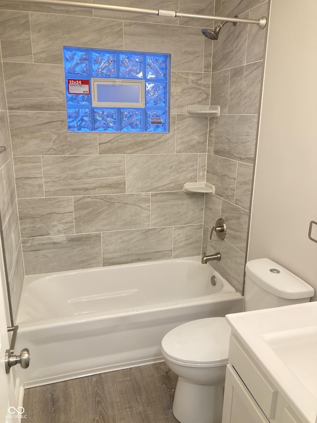 full bathroom featuring vanity, tiled shower / bath, hardwood / wood-style flooring, and toilet