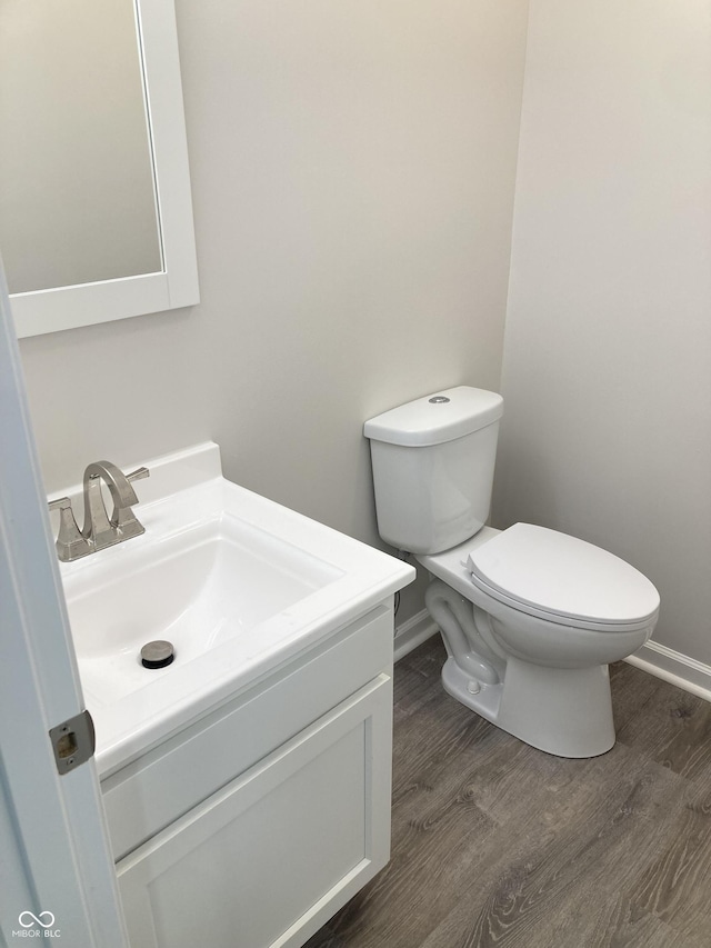 bathroom featuring hardwood / wood-style flooring, vanity, and toilet