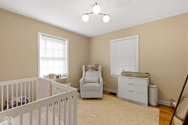 bedroom with wood-type flooring and a crib