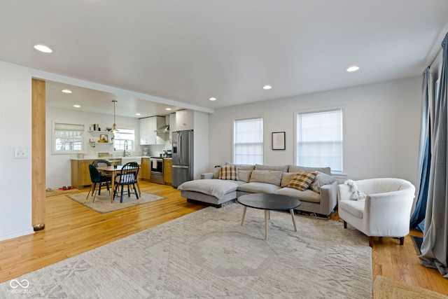 living room featuring sink, a wealth of natural light, and light wood-type flooring