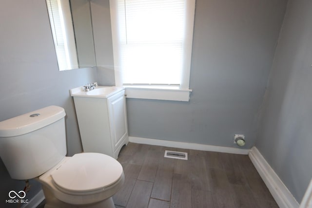 bathroom featuring hardwood / wood-style flooring, vanity, and toilet