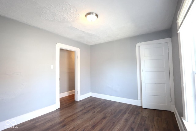 spare room with dark hardwood / wood-style flooring and a textured ceiling