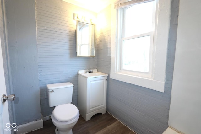 bathroom with vanity, a healthy amount of sunlight, hardwood / wood-style floors, and toilet