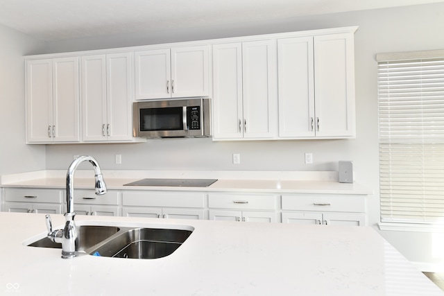 kitchen featuring white cabinetry, sink, and black electric cooktop