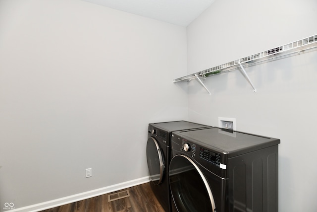 laundry area featuring dark hardwood / wood-style flooring and washing machine and clothes dryer