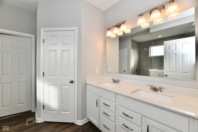 bathroom featuring vanity, wood-type flooring, and tiled shower