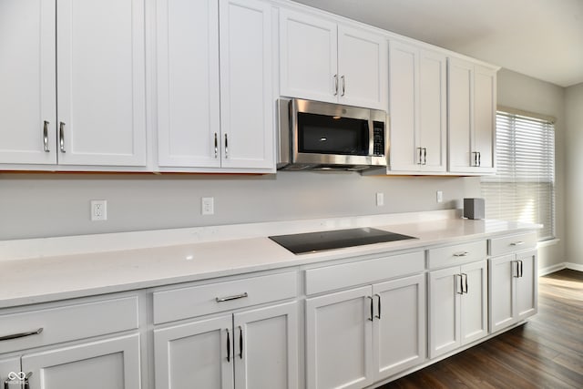 kitchen with white cabinetry, black electric stovetop, dark hardwood / wood-style flooring, and light stone counters