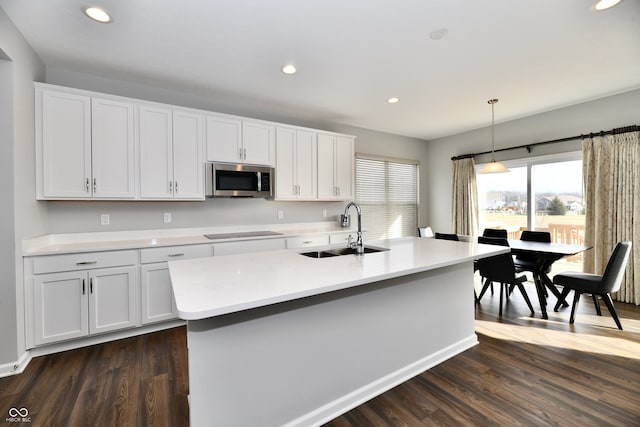 kitchen featuring pendant lighting, white cabinetry, black electric cooktop, and sink