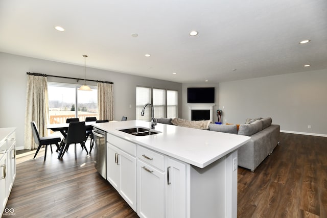 kitchen featuring pendant lighting, white cabinetry, sink, a kitchen island with sink, and stainless steel dishwasher