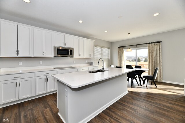 kitchen featuring pendant lighting, sink, and white cabinetry