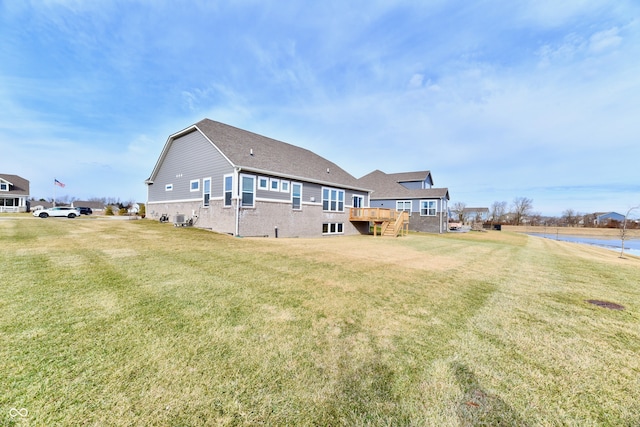 rear view of house with a wooden deck and a lawn