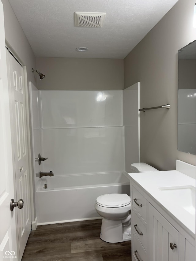 full bathroom with vanity, a textured ceiling, wood-type flooring, and toilet