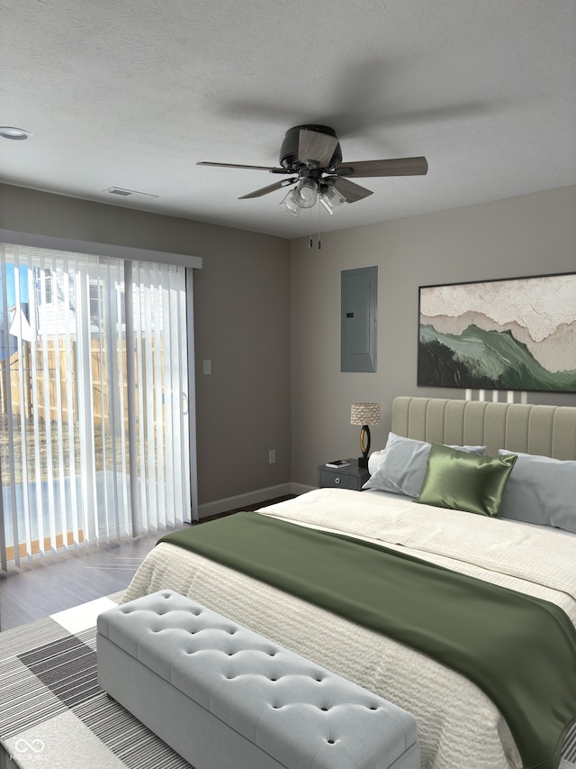 bedroom featuring ceiling fan, wood-type flooring, electric panel, and a textured ceiling