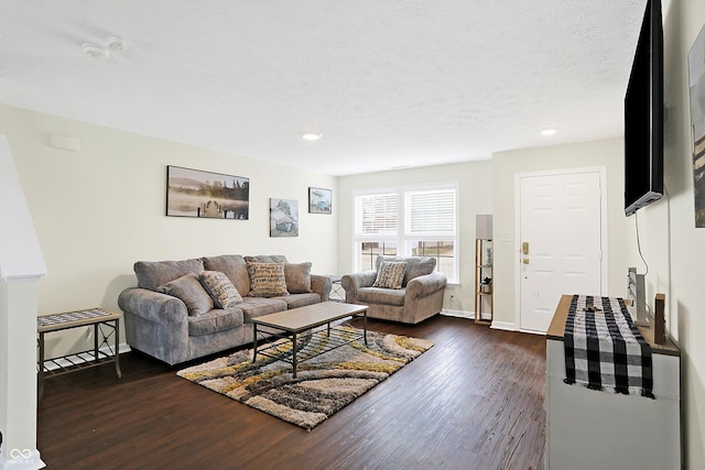 living room with dark wood-type flooring and a textured ceiling