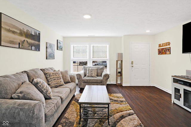 living room with dark wood-type flooring and a textured ceiling