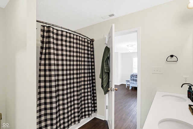 bathroom featuring vanity, hardwood / wood-style floors, a textured ceiling, and a shower with shower curtain