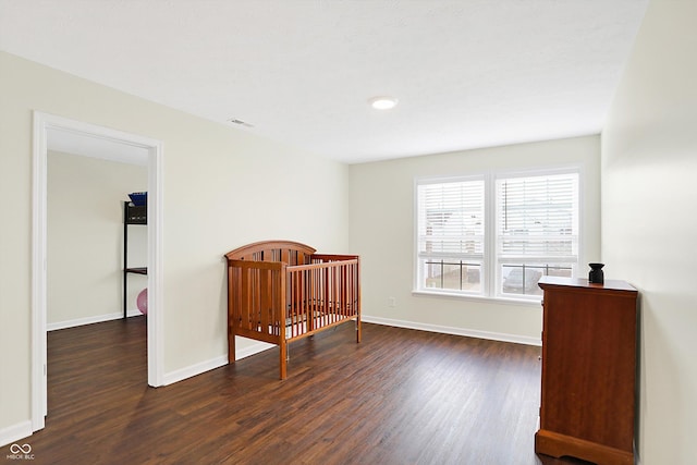 bedroom with dark hardwood / wood-style flooring