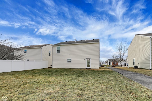 rear view of property featuring a lawn