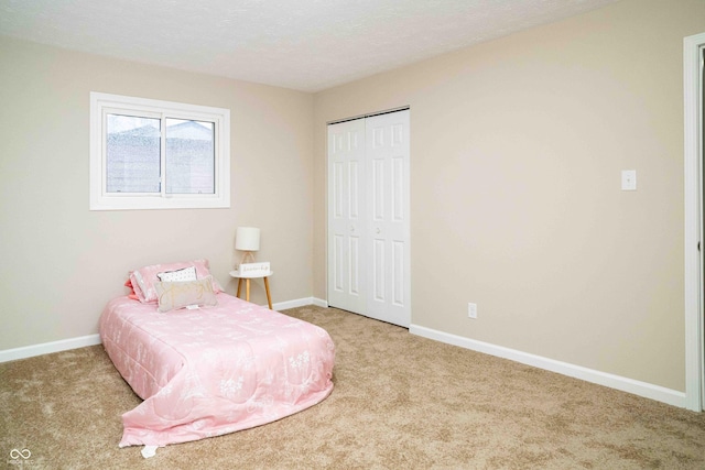 bedroom with light colored carpet, a closet, and a textured ceiling