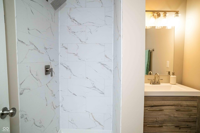 bathroom featuring a tile shower and vanity