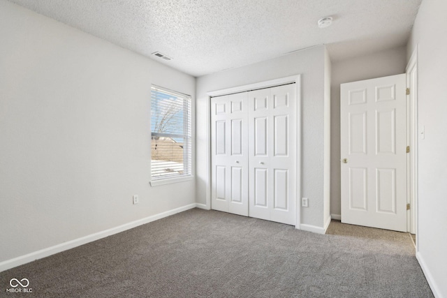 unfurnished bedroom with a closet, carpet, and a textured ceiling