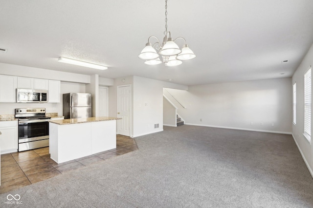 kitchen featuring stainless steel appliances, white cabinetry, carpet, and pendant lighting