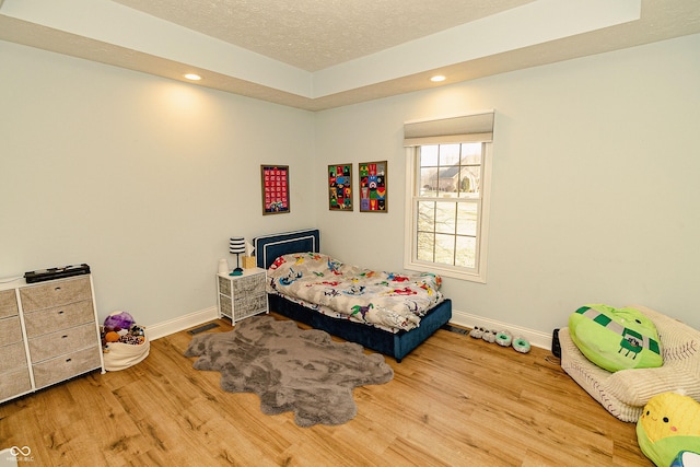 bedroom with hardwood / wood-style flooring and a textured ceiling