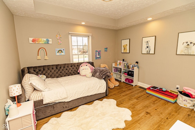 bedroom with wood-type flooring and a textured ceiling