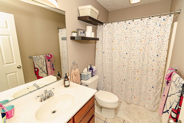 bathroom with tile patterned flooring, vanity, a textured ceiling, and toilet