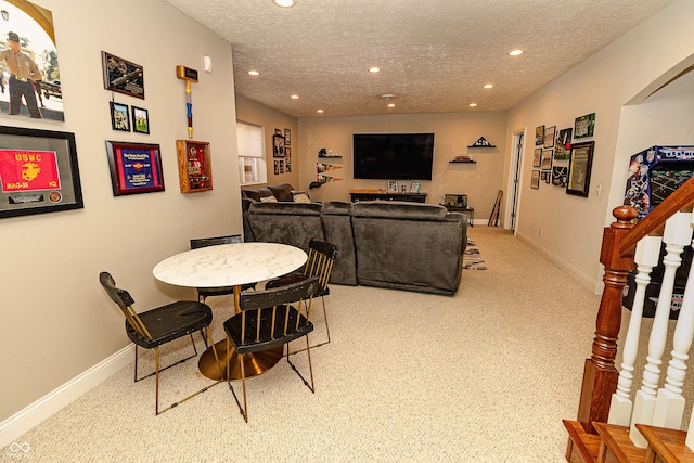 dining room featuring light carpet and a textured ceiling