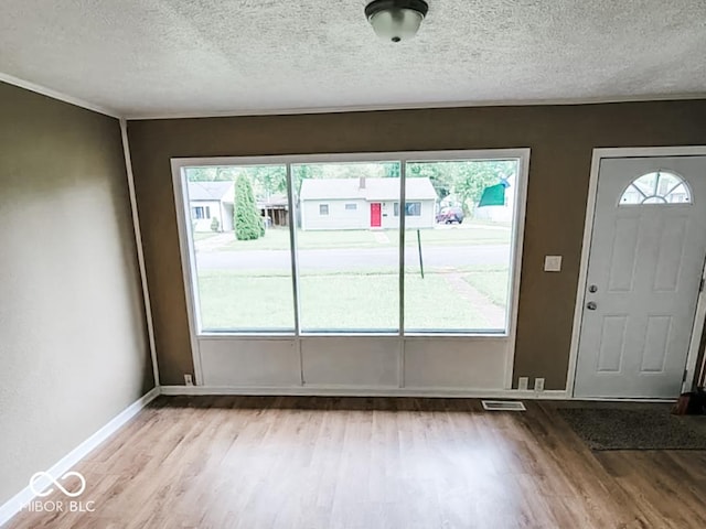 doorway featuring light hardwood / wood-style floors and a textured ceiling