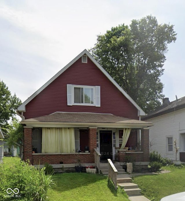 view of front facade featuring covered porch and a front yard