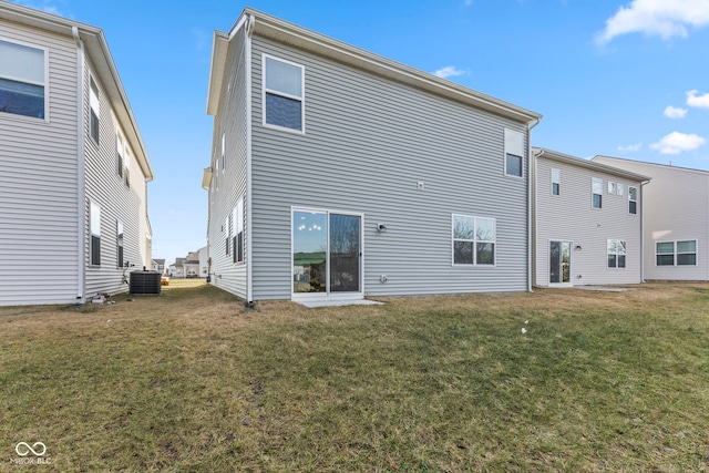 back of house with central AC unit and a yard