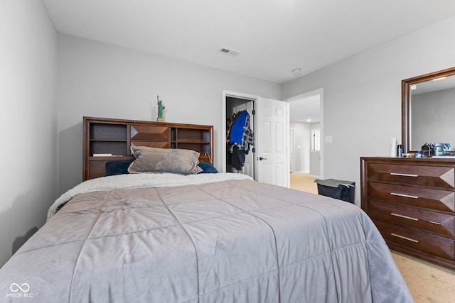 bedroom featuring a walk in closet, carpet flooring, and a closet